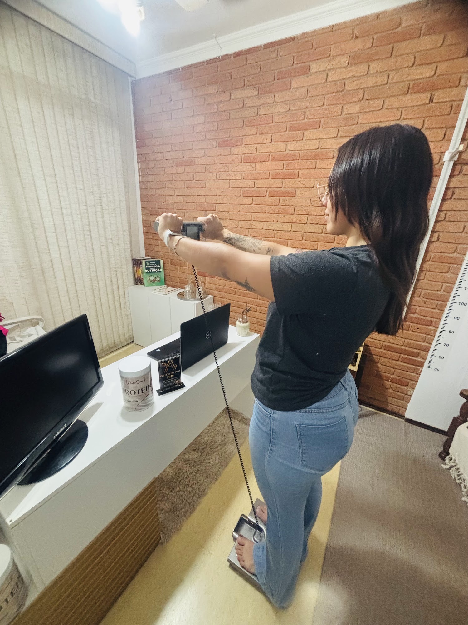 Paciente em pé sobre a balança de bioimpedância durante a avaliação